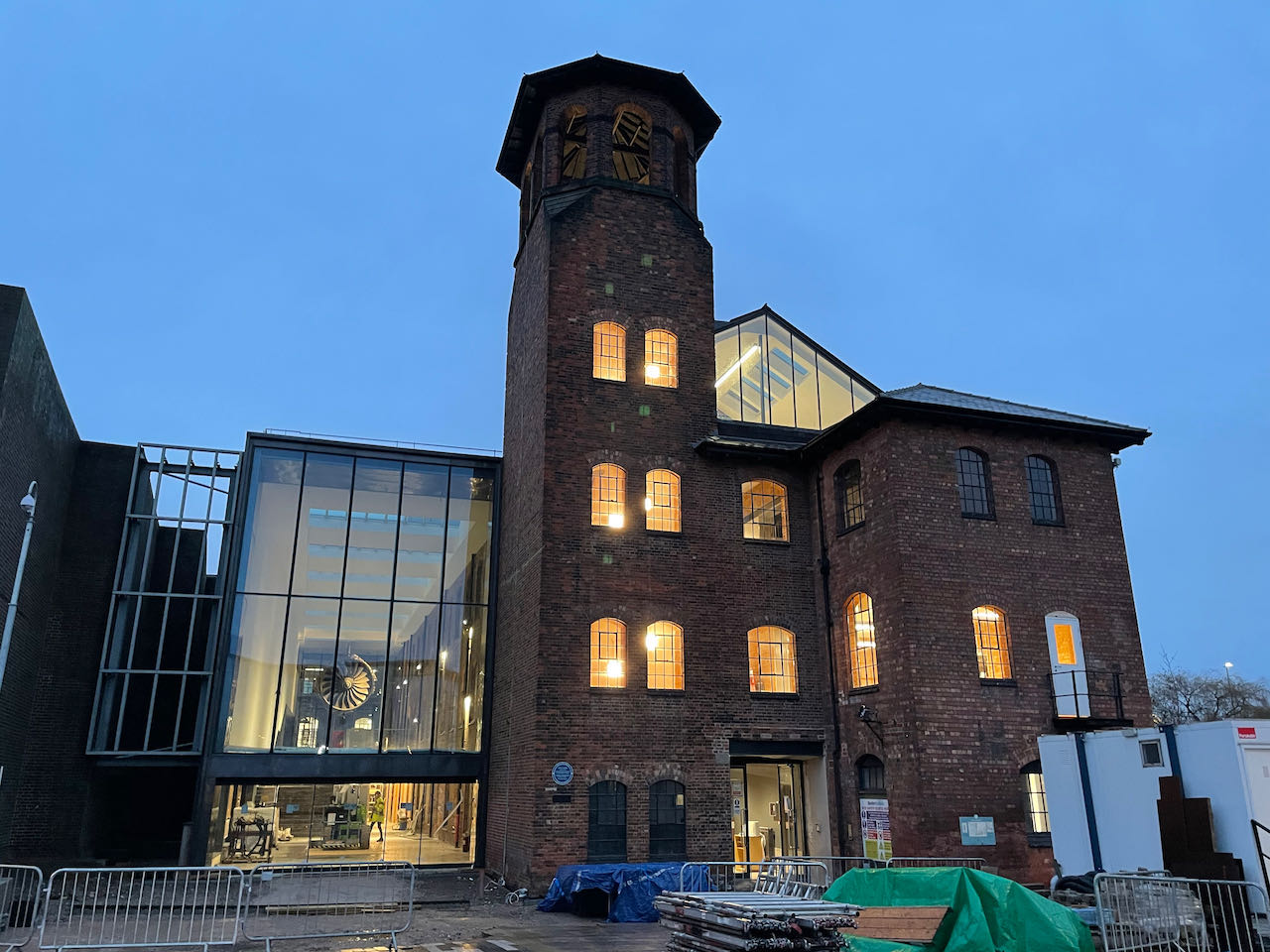 The frontage of the Silk Mill at twilight with the interior lights illuminating the building