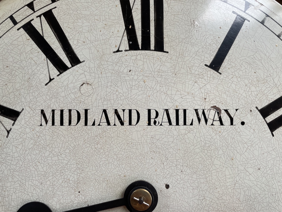 The top half of an old clock face with 'Midland Railway' featured prominently