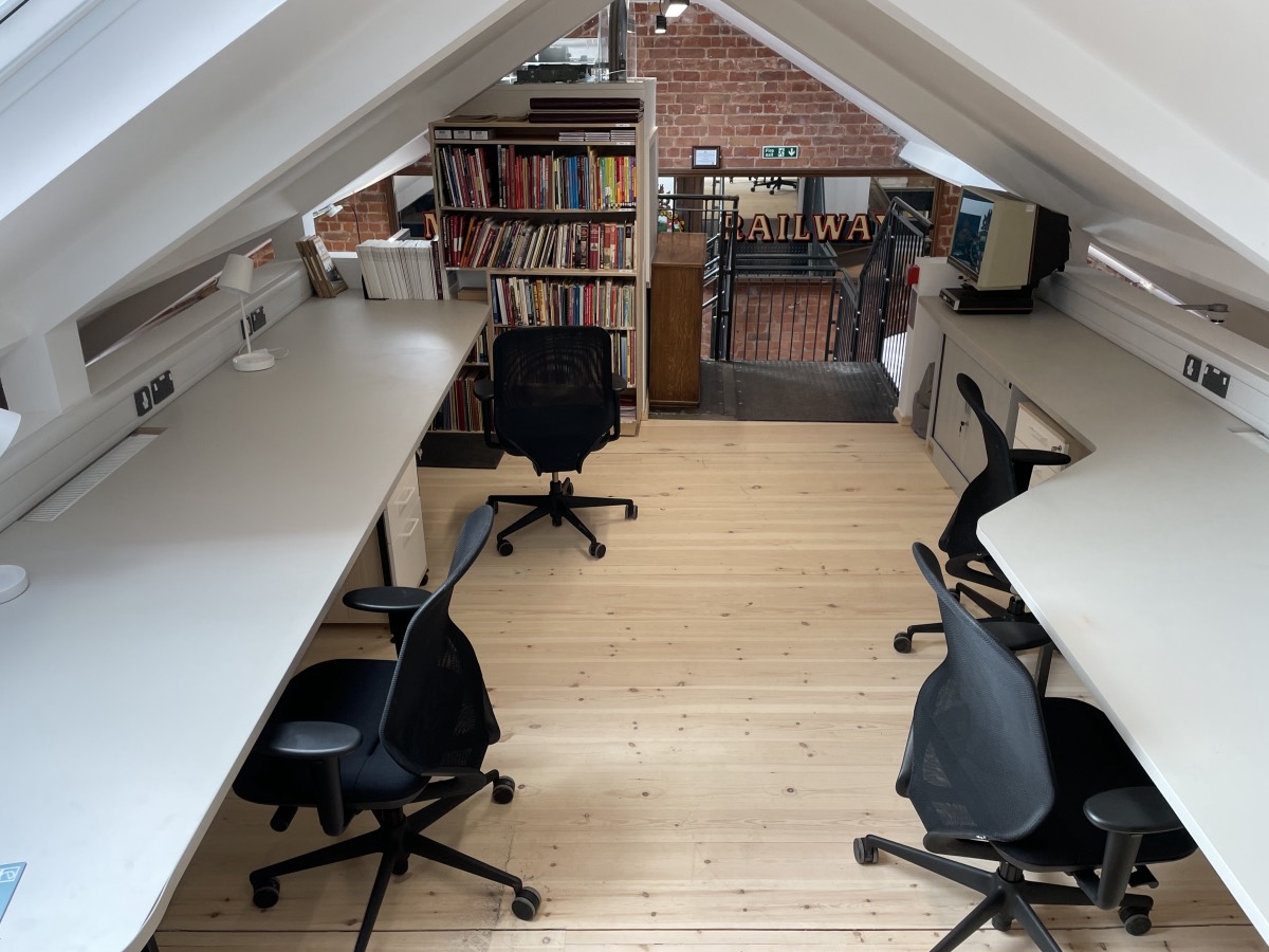 A room built into the eaves of the roof with desks either side and a central circulation space