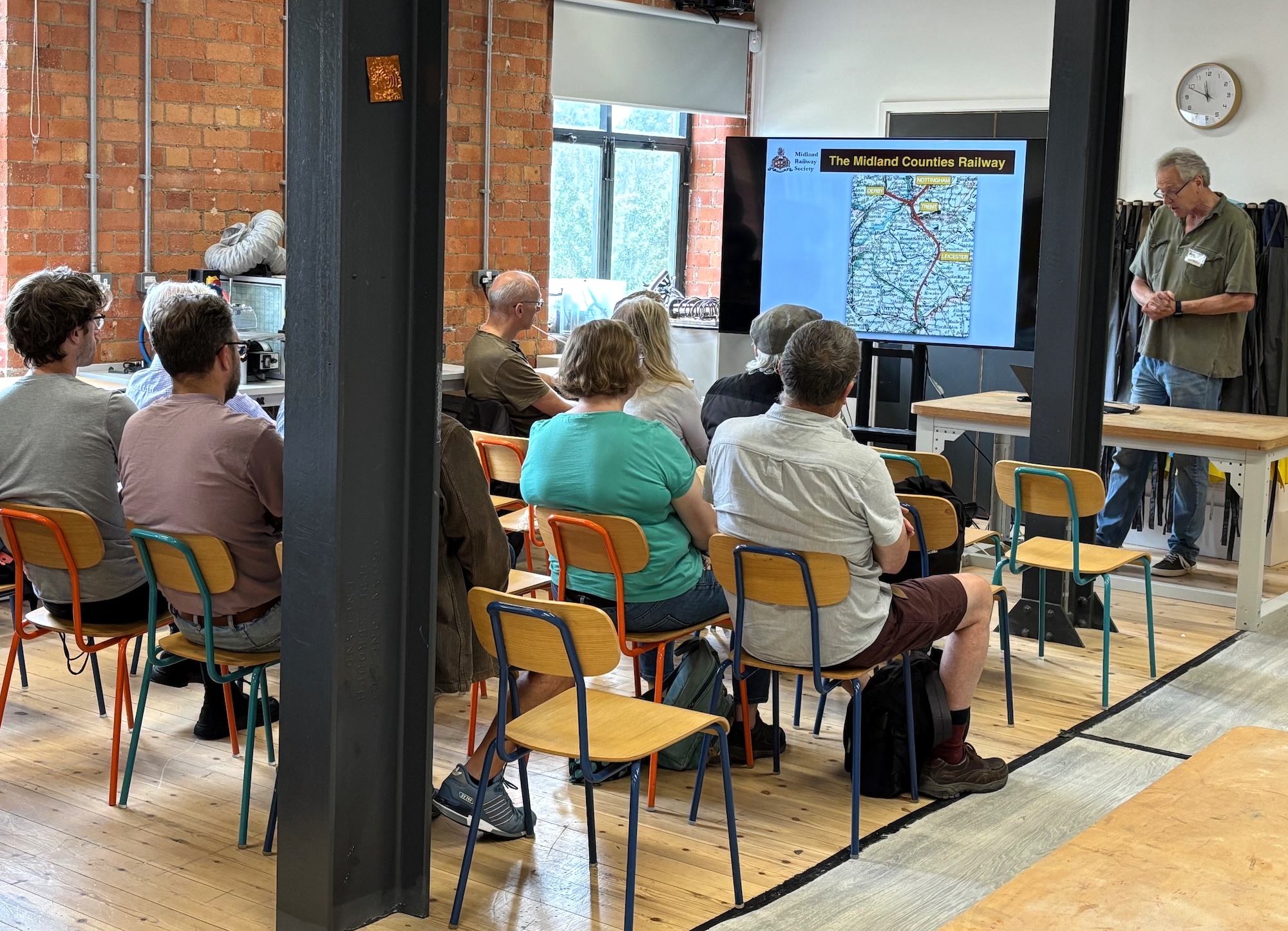 A view of the Studios where part of the Open Day is taking place. The view shows the long room with ten large tables with chairs where educational activities take place in the Museum of Making