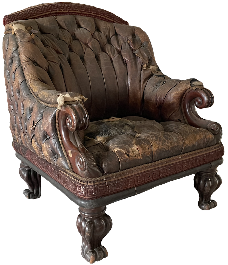 A very time-worn brown leather armchair