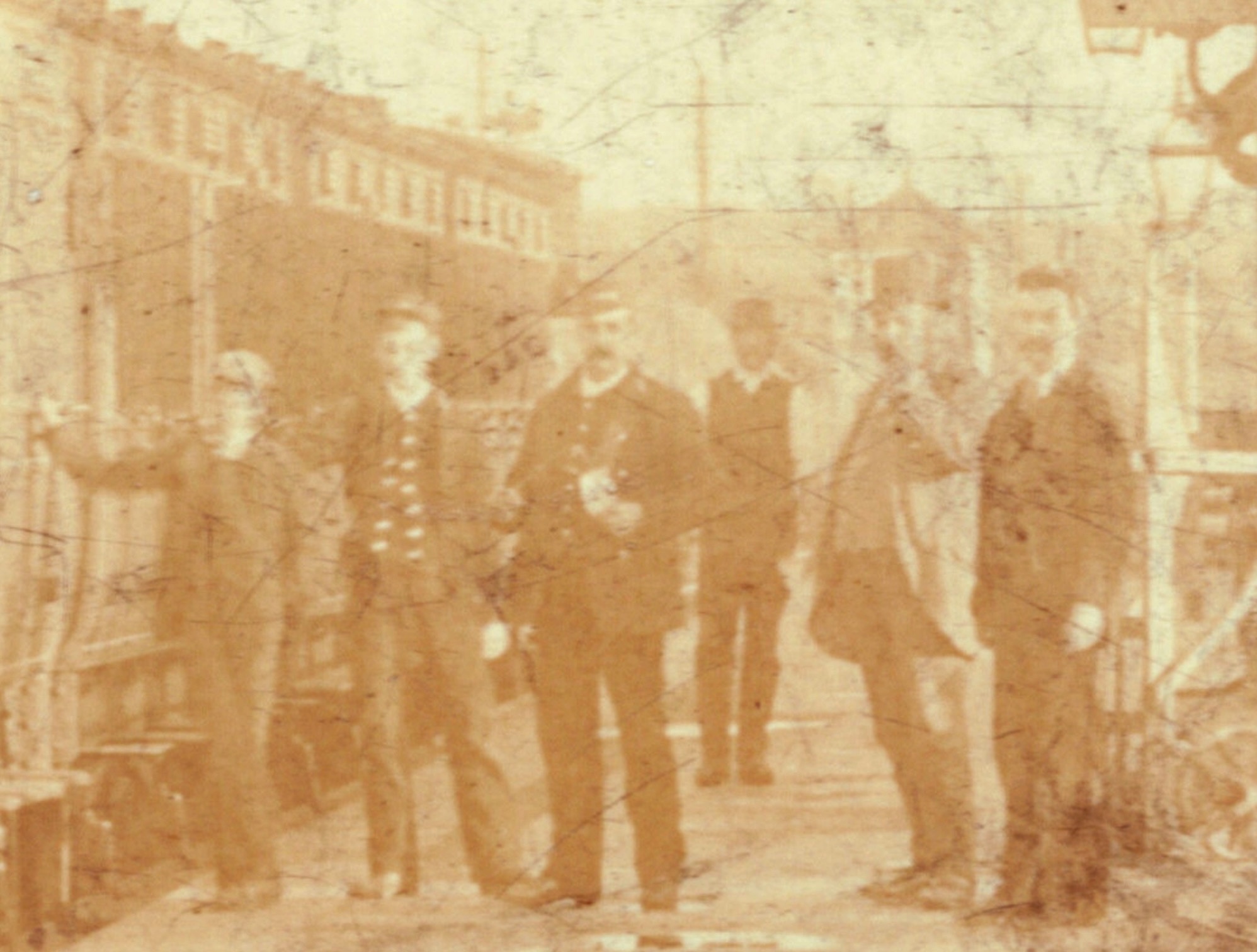 A close up of the above imageconcentrating ona group of men in the middle distance standing by the train. A signal box is visible in the background