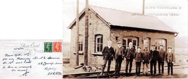 Postcard showing a group of eight working men of varying ages, one of whom is wearing Midland Railway uniform, posing in front of a brick-built weighbridge office and a set of three-throw points in the foreground.