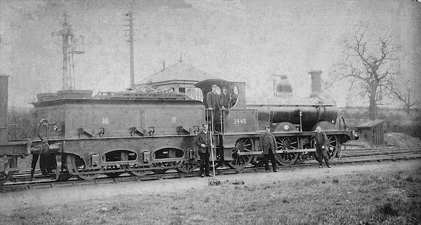 Midland Railway 0-6-0 No.1445 stands in a rural siding with the Driver and Foreman on the footplate and three other uniformed men (including one holding a shunter's pole). There is a small 10' square signal box behind the erngine.