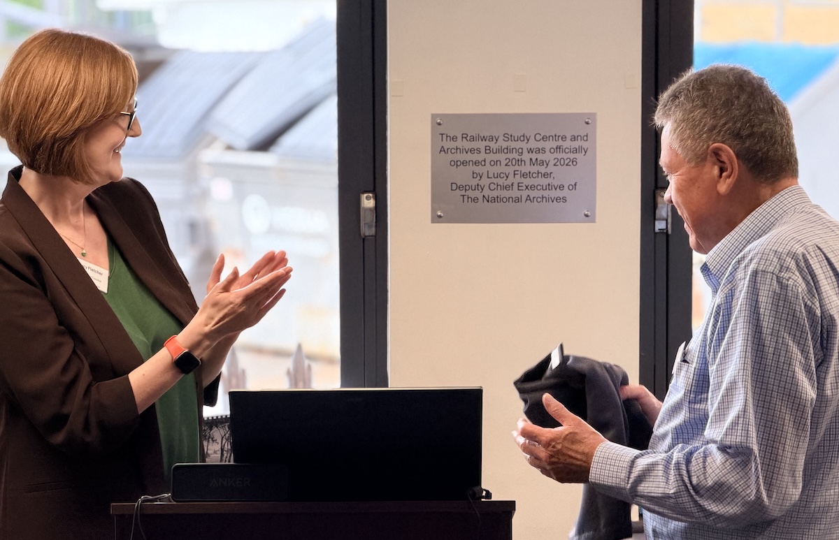 Two people in front of a plaque on a wall reading The Railway Study Centre and Archives Building was officially opened on 20th May 2026 by Lucy Fletcher, Deputy Chief Executive of The National Archives.