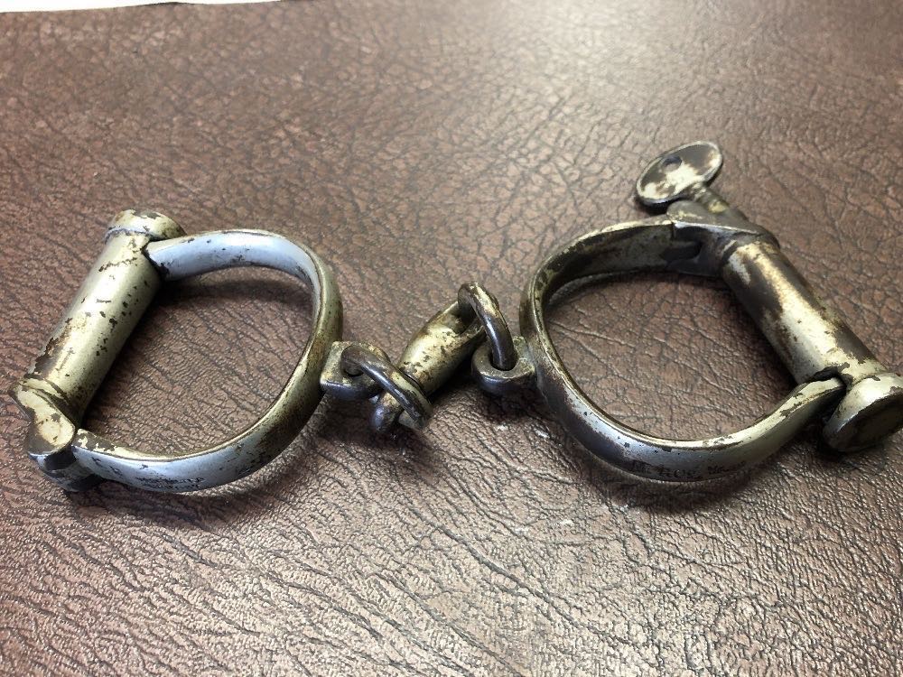 A close up of the handcuffs which are marked Hiatts Toughened and stamped MR Co.