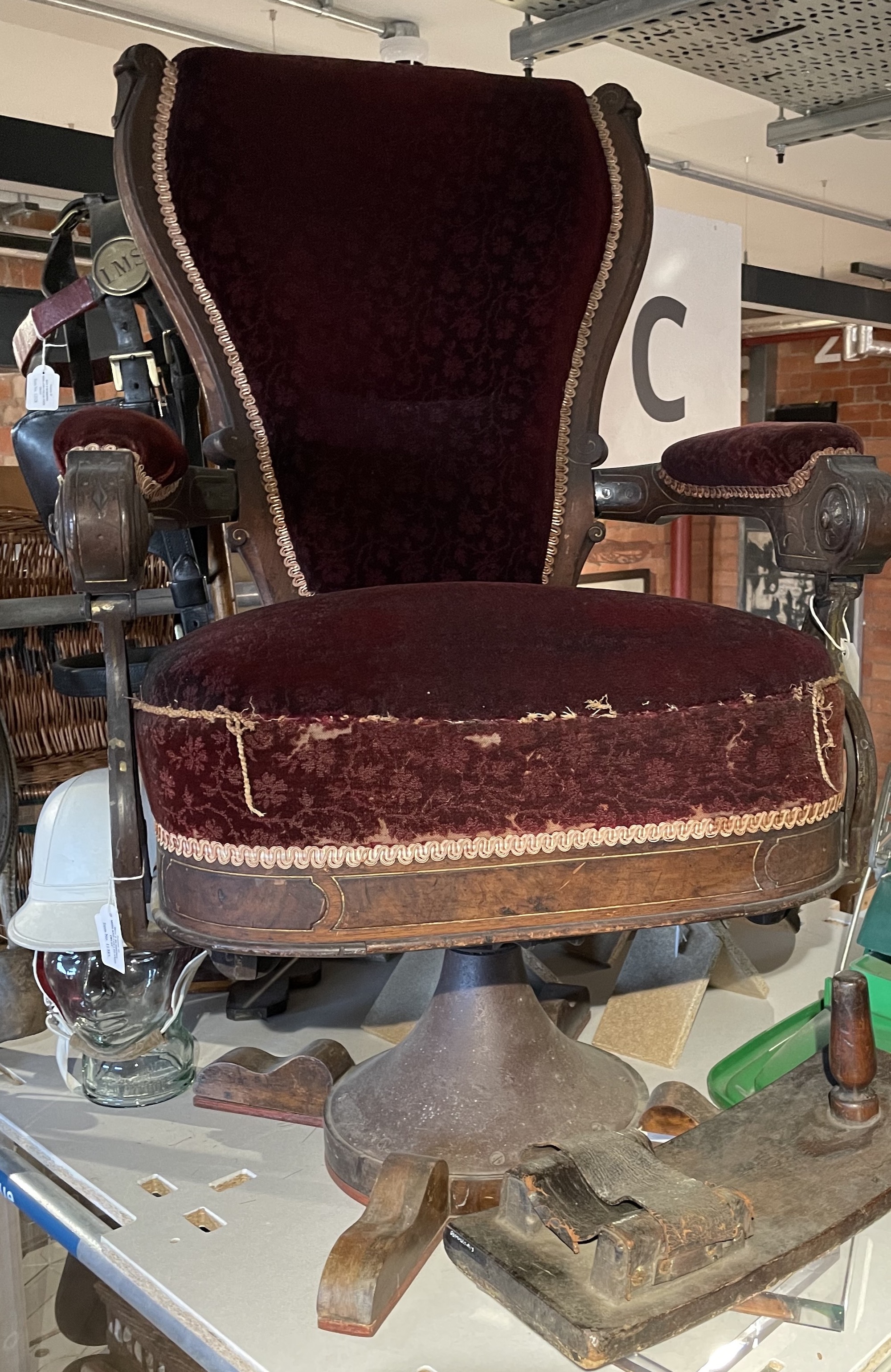 A swivel chair upholstered with deep red moquette