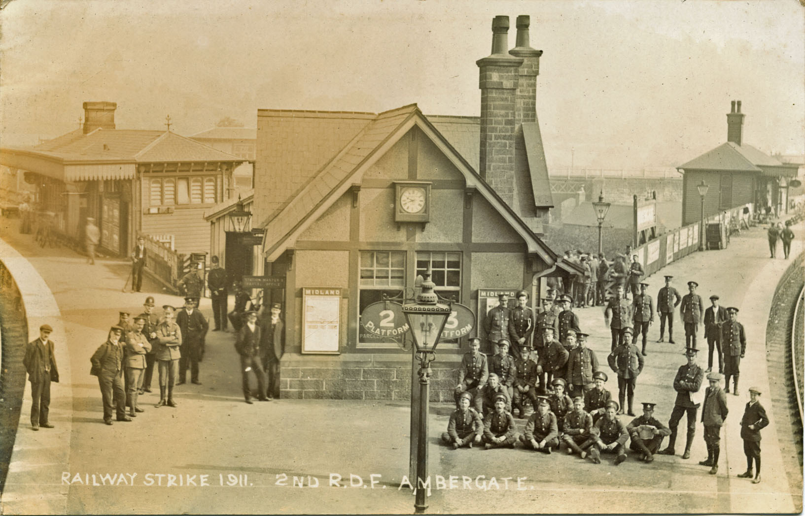 A photograph of troops parading on the platform of Ambergate Station to the great interest of locals. There is a caption which reads Railway Strike 1911 2nd R.D.F. Ambergate