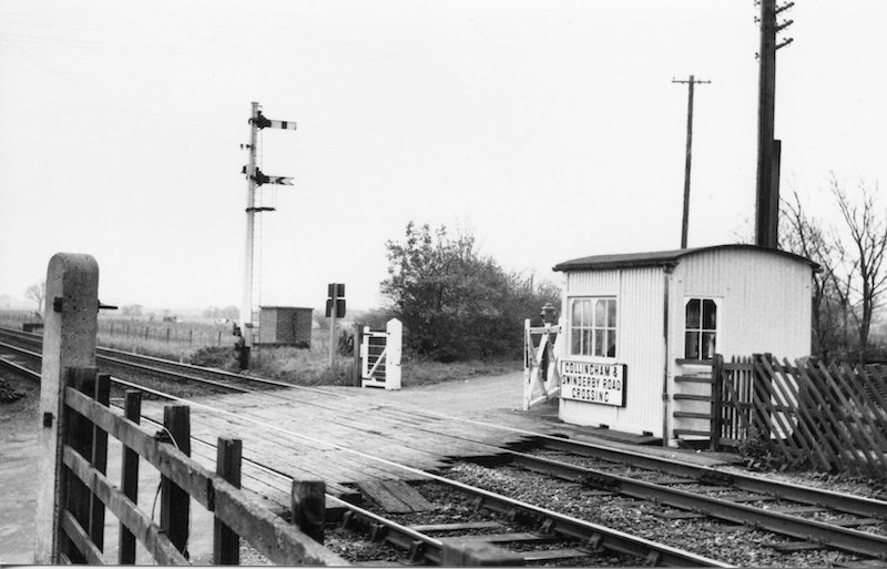 A photograph of the namebaord in its original location attached to a small wooden'ground frame hut' 